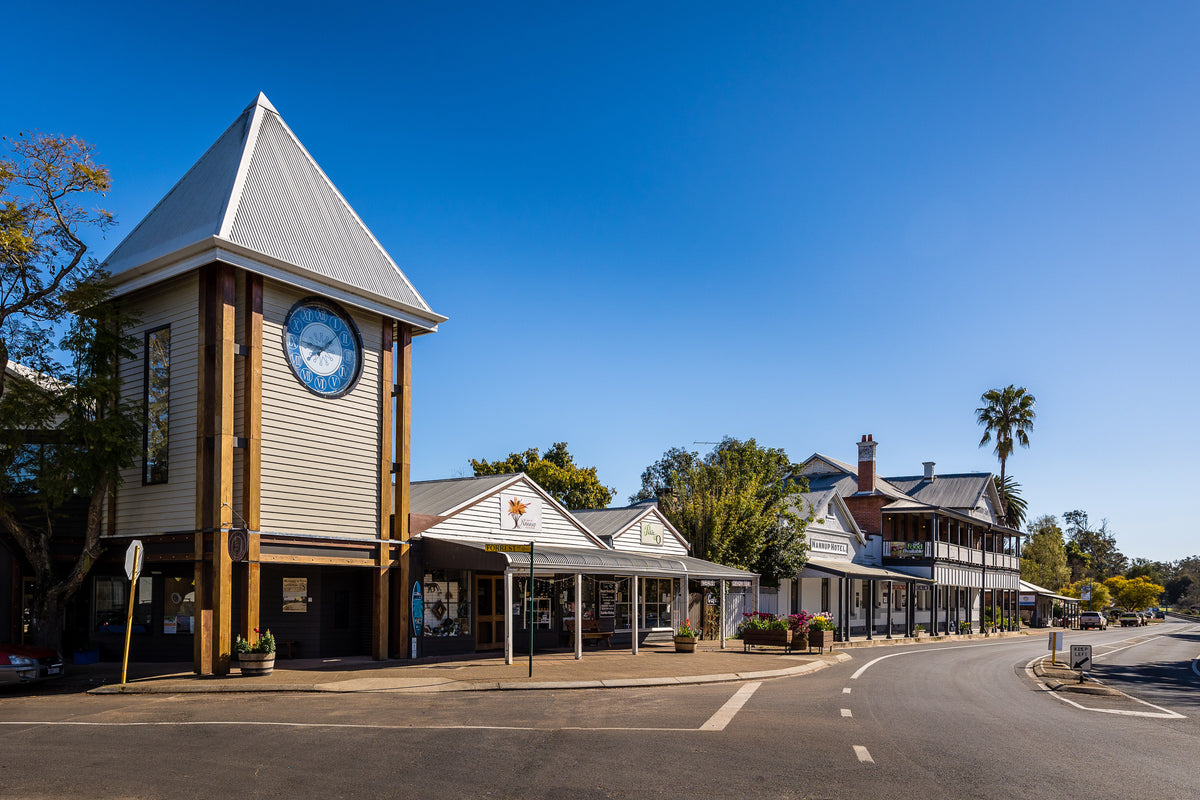 Street view of Nannup town on Forest Street. Large clock tower and Nannup Hotel. Blue skies.